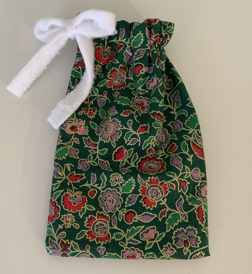 4.5 x 7 inch cotton small drawstring gift bag with dark green background and red and pink flowers with light green leaves