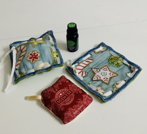 No sew coaster and sachet with light blue background and white, red, green iced Christmas Cookie pattern, Scentsy oil and Scentsy Pak optional accessories also pictured
