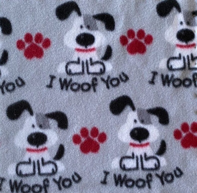 Gray fleece fabric with black and white dogs, red paw prints, and I Woof You text