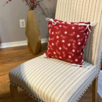 Red fleece pillow with white shooting stars on chair