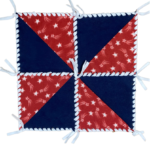 Navy Blue Fleece 10" squares with Red and White shooting Star half square triangles on alternating corners to form pinwheel design, laced together with white fleece ribbon into a 4th of July table topper.