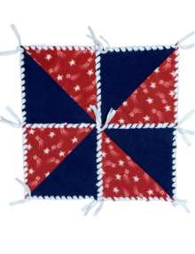 Navy Blue Fleece 10" squares with Red and White shooting Star half square triangles on alternating corners to form pinwheel design, laced together with white fleece ribbon into a 4th of July table topper.
