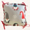 Gnome Pillow with gray background, white snowflakes, and gnomes wearing red, green and gray stocking caps, the pillow is laced with a red grosgrain ribbon