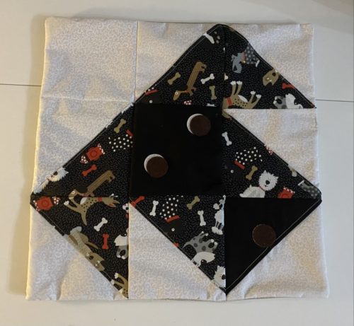 Nine patch puppy dog face quilt block in black, tan, white, red and gray with brown eyes and brown nose