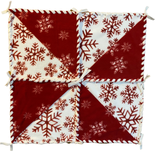 25 inch fleece pinwheel table topper in ivory with red snowflakes and red with white snowflakes